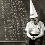 Child wearing a dunce cap